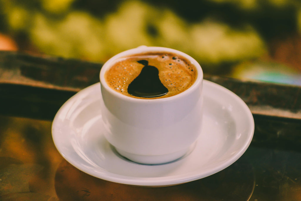 white cup filled with frothy coffee sits